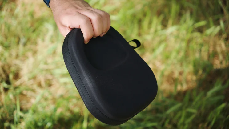 Our reviewer holding the carrying case of the Sennheiser Momentum 5 Wireless over-ear headphones by its indent