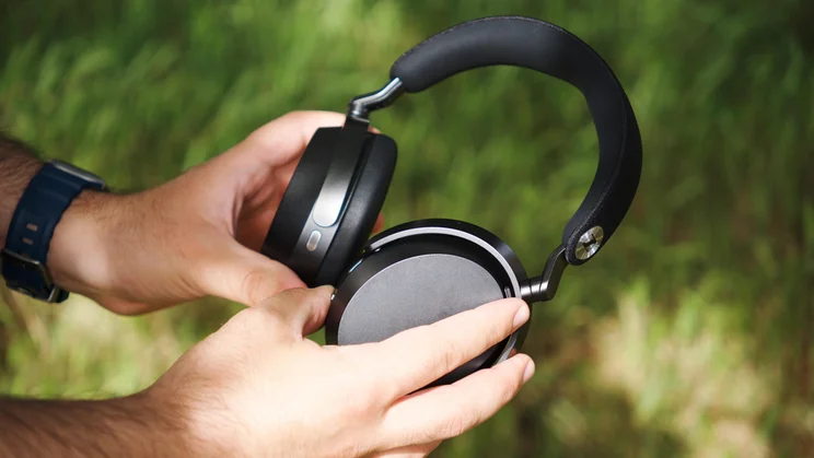 The Sennheiser Momentum 5 Wireless over-ear headphones being held in the hands of our reviewer