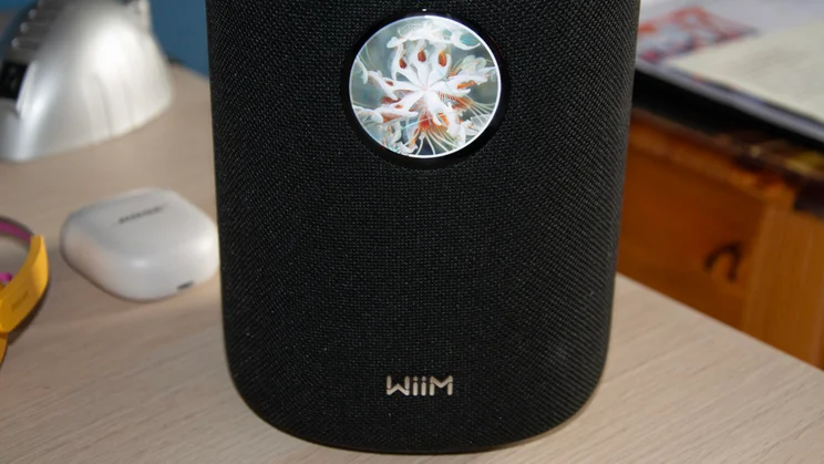 Front view of the WiiM Sound wireless speaker with album artwork displayed on the digital display
