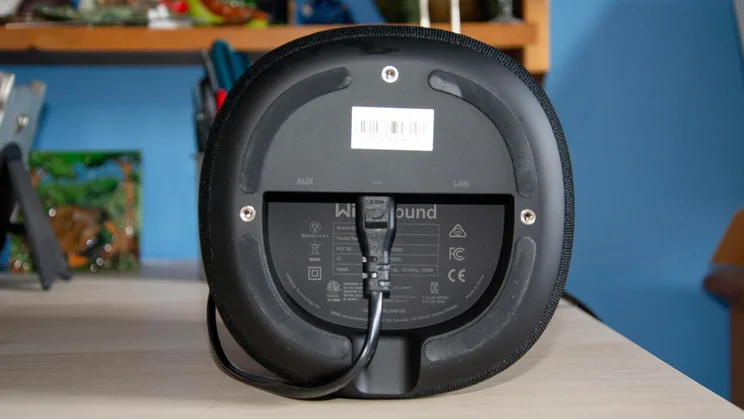 The underside of the WiiM Sound wireless speaker showing the power connection plugged in