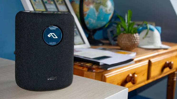 The WiiM Sound wireless speaker standing on the corner of a desk