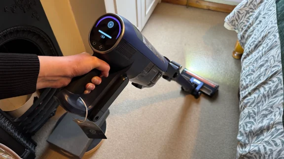 A picture of the Shark PowerDetect Speed Clean and Empty Pet Pro being used to vacuu a bedroom carpet