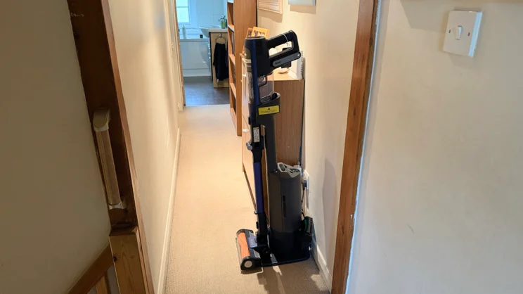 A picture of the Shark PowerDetect Speed Clean and Empty Pet Pro in a corridor from the left side