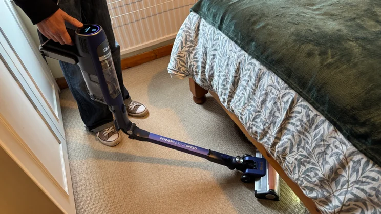 A picture of the hinge on the Shark PowerDetect Speed Clean and Empty Pet Pro being used to clean under a bed