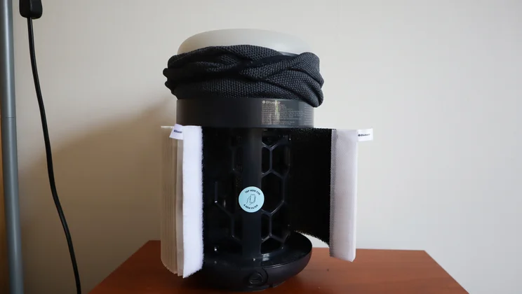 The Blueair Mini Restful air purifier on a bedside table, with its filter partly removed