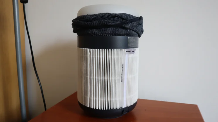 The Blueair Mini Restful air purifier on a bedside table, with the outer cover partially removed
