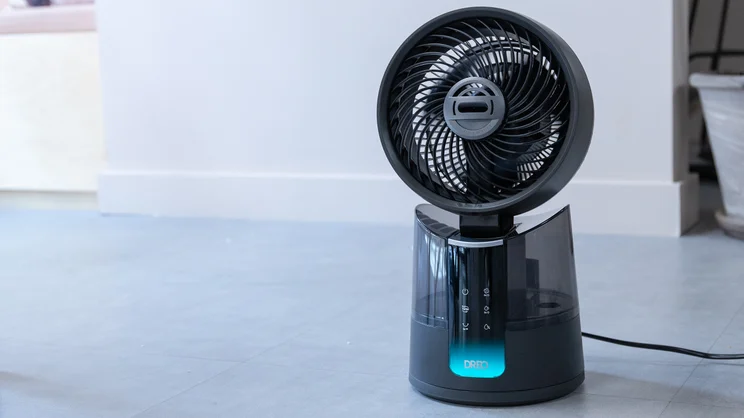 The Dreo TurboCool Misting Fan 516S on the floor of an office, plugged in and switched on