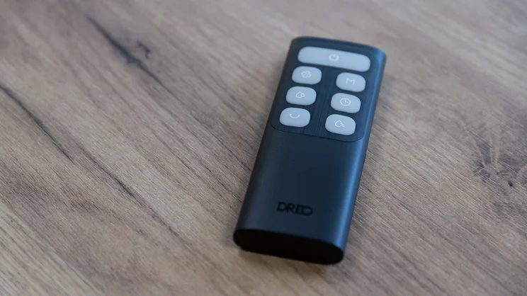 The Dreo TurboCool Misting Fan 765S's remote control on a wooden table