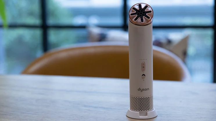 The Dyson HushJet Mini Cool fan standing on an office table, in its base