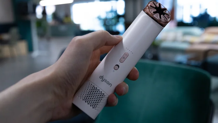 A hand holding the Dyson HushJet Mini Cool fan