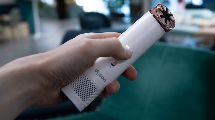 A hand holding the Dyson HushJet Mini Cool fan