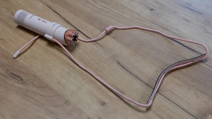 The Dyson HushJet Mini Cool fan with its lanyard attachment on an office table