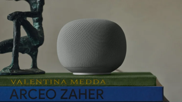 The Google Home Speaker in porcelain, pictured on top of a stack of books