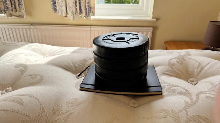 A series of 2.5kg weights and a notebook placed on top of the Odd Company Blenheim 1500 mattress
