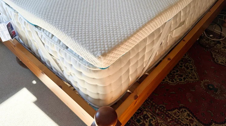 A closeup of a corner of the Simba Cool Foam mattress topper, on a mattress