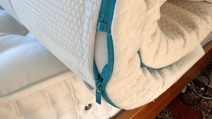 The edge of the Simba Cool Foam mattress topper. A closeup of the removeable cover's zip