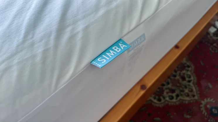 The edge of the Simba TripleShield Tencel Cool mattress protector. A closeup of the logo label