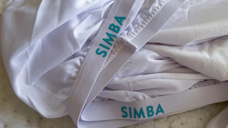 A closeup of the Simba TripleShield Tencel Cool mattress protector's skirt and elasticated strap