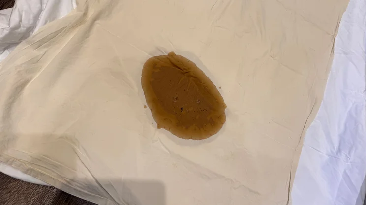 The Simba TripleShield Tencel Cool mattress protector underneath a piece of polycotton sheet. Coffee has been spilled on the top sheet