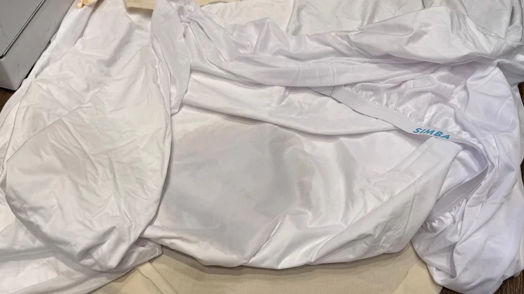 The underside of the The Simba TripleShield Tencel Cool mattress protector, slightly stained with coffee
