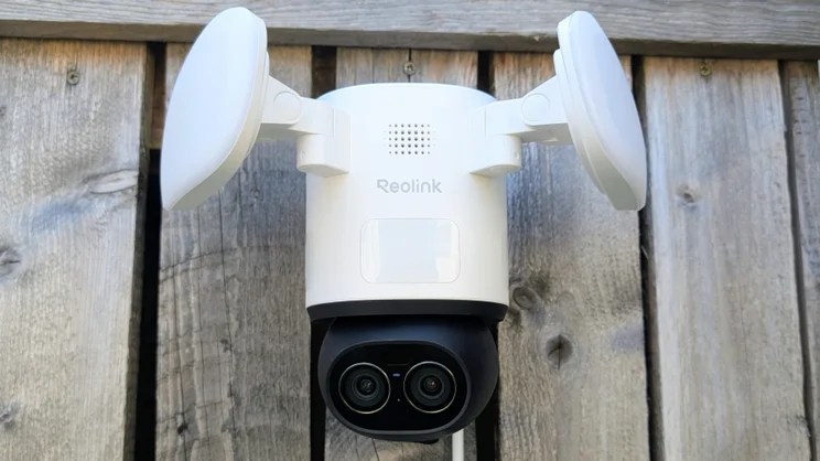 The Reolink TrackFlex, pictured from in front, mounted on a wooden fence