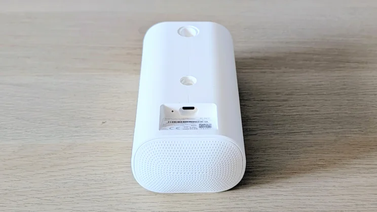 The Ring Spotlight Cam Pro Plug-In (2nd gen) laid on its front on a wood surface with the rear showing