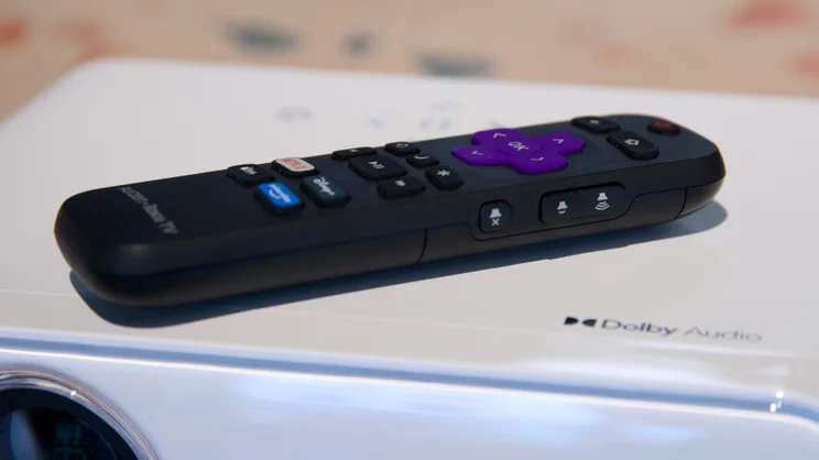 The Roku remote lying on top of the Aurzen Eazze D1R projector