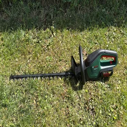 Bosch AdvancedHedgeCut 36V - wide shot of trimmer laid on grass