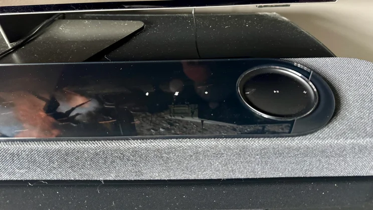 Close-up of the reflections from a television on the glass panel on top of the Bose Lifestyle Ultra Soundbar