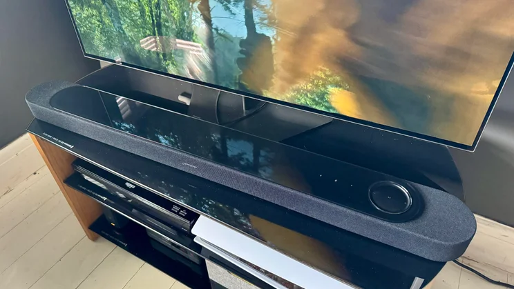 Top-down view of the Bose Lifestyle Ultra Soundbar on a TV stand in front of a television
