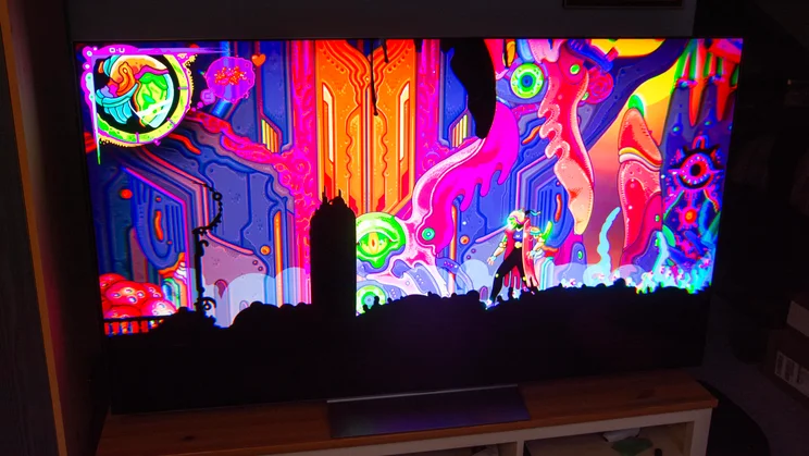 The 65in LG C6 OLED TV on a wooden stand displaying an image from the video game Ultros