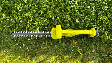 Ryobi RY18HT40B - wide shot of whole trimmer, resting on grass