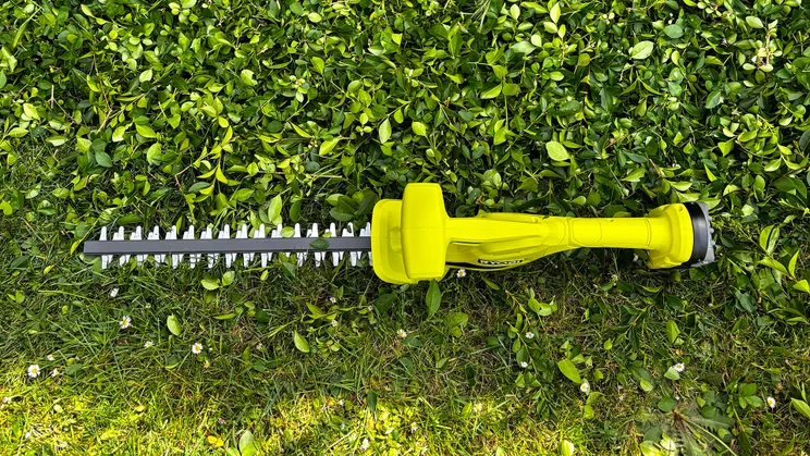 Ryobi RY18HT40B - wide shot of whole trimmer, resting on grass