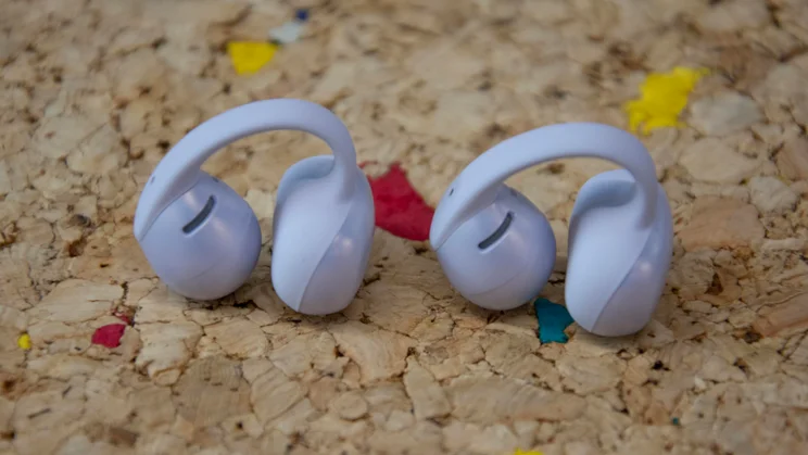 The Shokz OpenDots Air earbuds side by side on a cork table