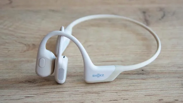 The Shokz OpenRun Pro bone-conduction headphones on a wooden table