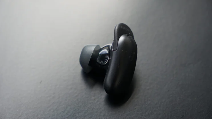 A single Soundcore Liberty 5 Pro wireless earbuds lying on its side on a black table