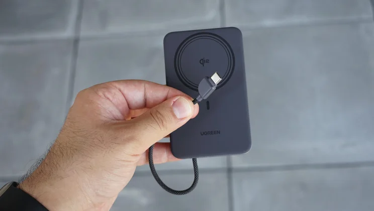 The UGreen MagFlow Air (10,000mAh) with its built-in USB-cable in front of its wireless charging section