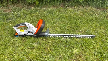 Wide shot of VonHaus G-Series 40V hedge trimmer, lying on grass unsheathed