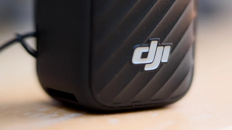 A close up snot of the DJI logo on the handle of the DJI OSMO Pocket 4P