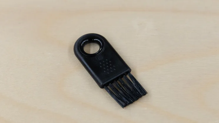 The AeroPress Manual Coffee Grinder's crevice cleaning brush