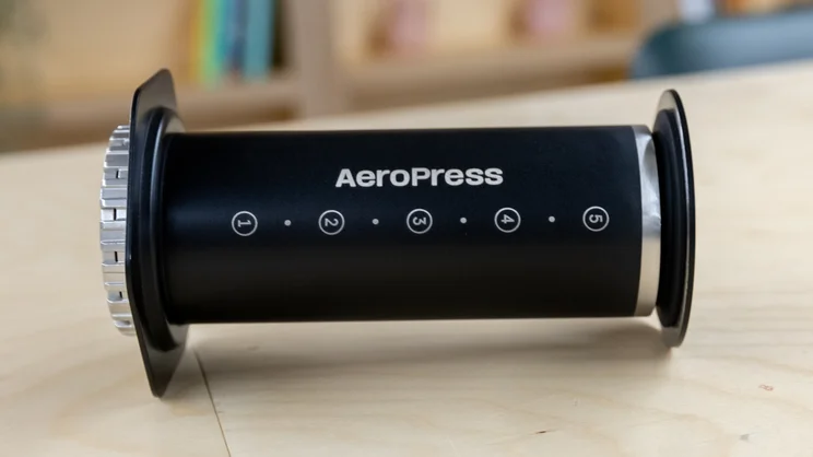 The AeroPress Steel coffee maker on its side, on a table in an office