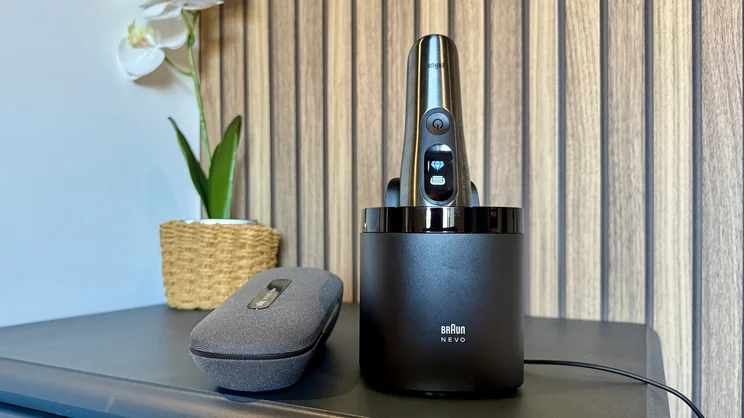 The Braun Nevo electric shaver in its cleaning station on a table, alongside the Power Travel case