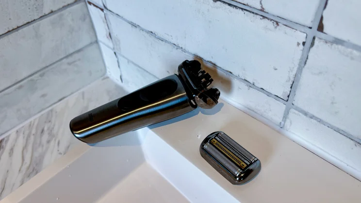 The Braun Nevo electric shaver, with its foil head removed, on the side of a bathroom sink