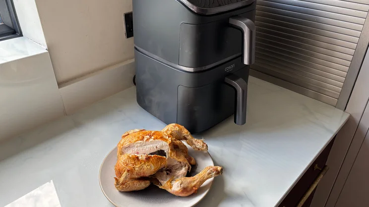 The Cosori Turbo Tower air fryer on a kitchen worktop, alongside a cooked chicken