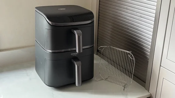 The Cosori Turbo Tower air fryer on a kitchen worktop, alongside its roasting plate