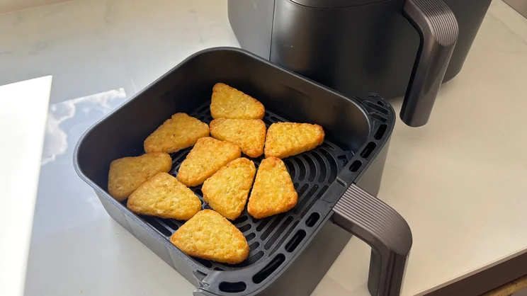 Cooked hash browns in the drawer of the Cosori Turbo Tower air fryer