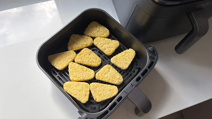 Raw hash browns in the drawer of the Cosori Turbo Tower air fryer
