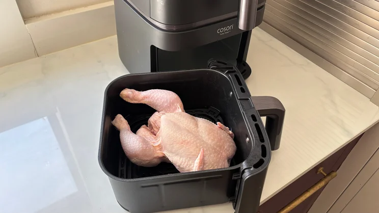 A raw chicken in the larger drawer of the Cosori Turbo Tower air fryer