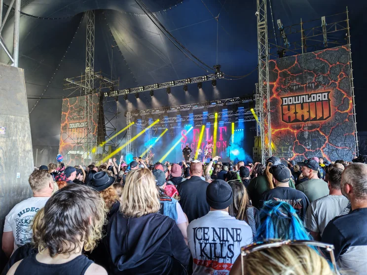A crowd around a stage, spotlights shining