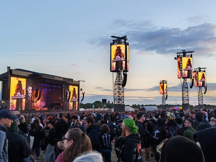 A stage at a festival with several screens displaying the performers